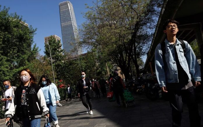 Orang-orang berjalan di jalan di Central Business District (CBD) Beijing pada jam sibuk pagi hari, di Beijing, China 18 April 2023. Foto: Reuters/Tingshu Wang.