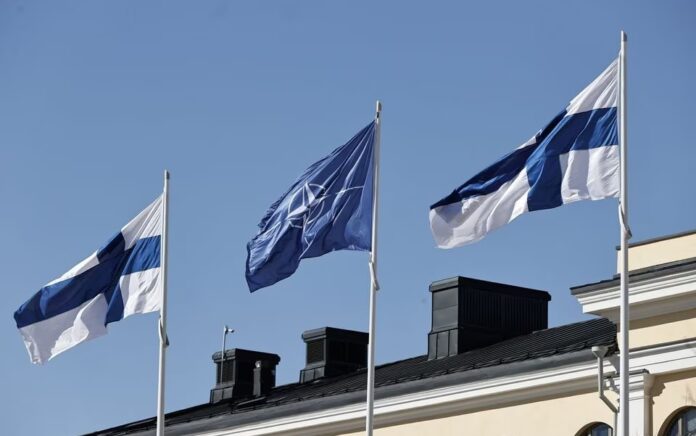 Bendera Finlandia dan NATO berkibar di halaman Kementerian Luar Negeri, menjelang aksesi Finlandia ke NATO, di Helsinki, Finlandia, 4 April 2023. Foto: Lehtikuva/Antti Hamalainen/Reuters.