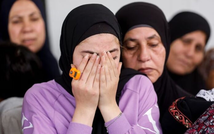 Kerabat berduka saat pemakaman seorang warga Palestina yang tewas dalam serangan Israel, saat pemakamannya di dekat Jericho di Tepi Barat yang Diduduki Israel, 10 April 2023. Foto: Reuters/Mohammed Torokman.