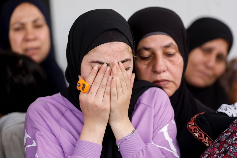 Kerabat berduka saat pemakaman seorang warga Palestina yang tewas dalam serangan Israel, saat pemakamannya di dekat Jericho di Tepi Barat yang Diduduki Israel, 10 April 2023. Foto: Reuters/Mohammed Torokman.