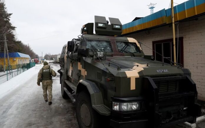 Seorang anggota Layanan Penjaga Perbatasan Negara Ukraina berjaga-jaga di pos pemeriksaan Senkivka dekat perbatasan dengan Belarus dan Rusia di wilayah Chernihiv, Ukraina 16 Februari 2022. Foto: Reuters/Valentyn Ogirenko.