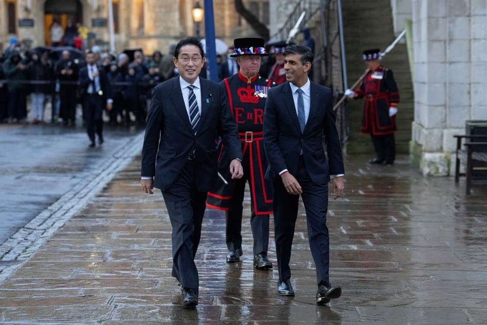 Perdana Menteri Inggris, Rishi Sunak, berjalan bersama Perdana Menteri Jepang, Fumio Kishida, setelah menandatangani perjanjian pertahanan di Tower of London pada 11 Januari 2023 di London, Inggris. Foto: Carl Court/Pool/Reuters.