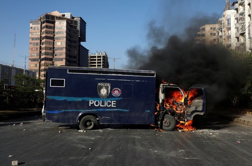Sebuah kendaraan polisi terbakar saat protes pendukung mantan Perdana Menteri Pakistan Imran Khan setelah penangkapannya, di Karachi, Pakistan, 9 Mei 2023. Foto: Reuters/Akhtar Soomro.