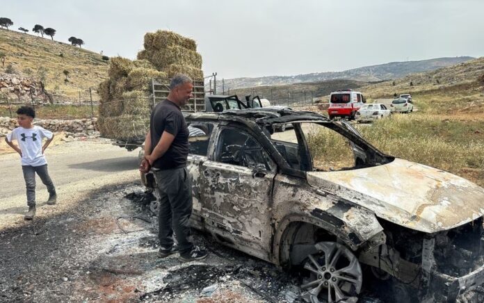 Warga Palestina memeriksa mobil yang dibakar oleh pemukim Israel selama bentrokan di dekat Ramallah di Tepi Barat yang diduduki Israel 26 Mei 2023. Foto: Reuters/Ali Sawafta.