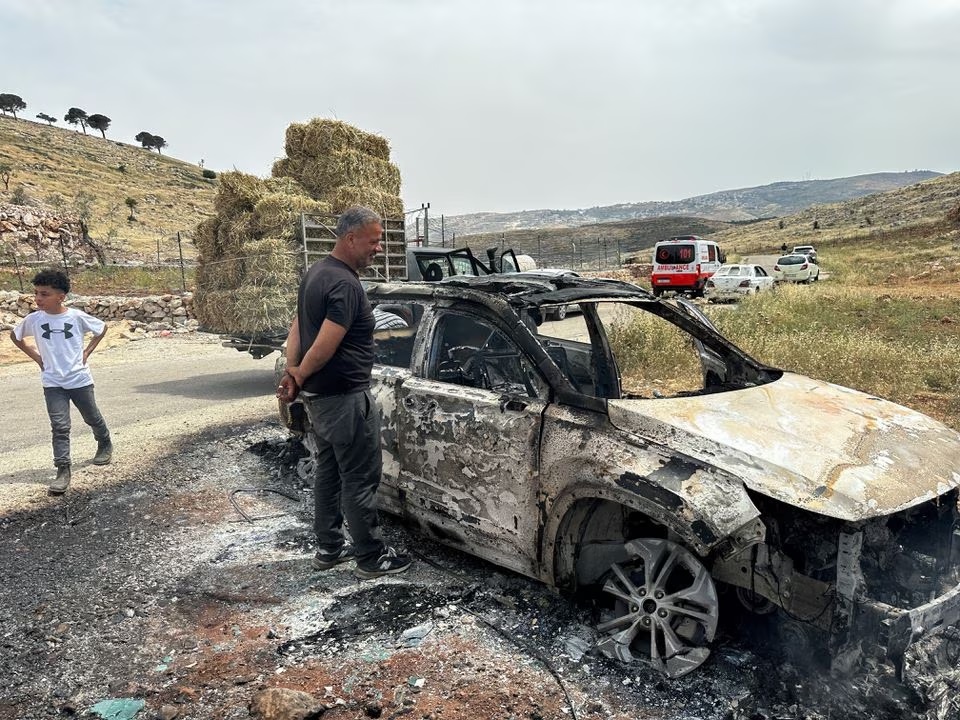 Warga Palestina memeriksa mobil yang dibakar oleh pemukim Israel selama bentrokan di dekat Ramallah di Tepi Barat yang diduduki Israel 26 Mei 2023. Foto: Reuters/Ali Sawafta.