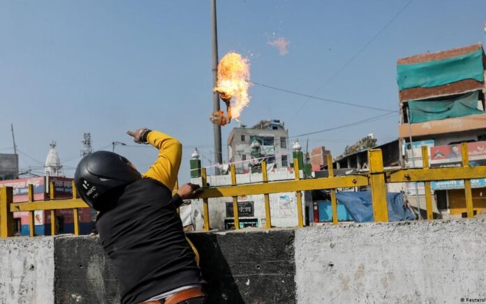 Seorang simpatisan Partai Bharatiya Janata melemparkan bom molotov ke arah sebuah masjid di New Delhi, ketika bentrok antara pendukung pemerintah dan kelompok yang anti UU Kewarganegaraan berkecamuk di ibu kota (24/2). Foto: Reuters/D. Siddiqui.