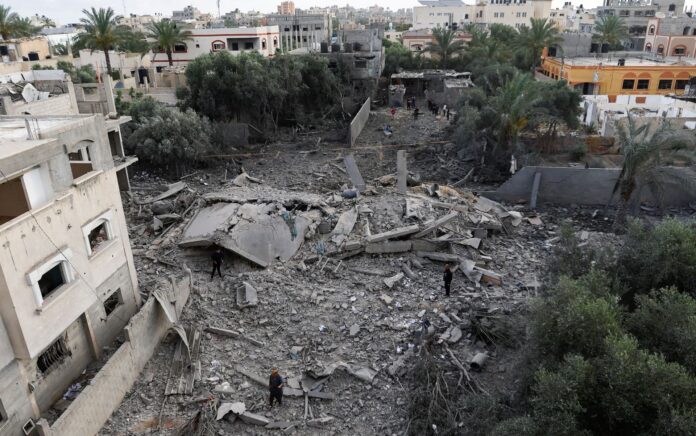 Warga Palestina berkumpul di lokasi serangan udara Israel di tengah pertempuran Israel-Gaza di kota Deir al-Balah di Jalur Gaza tengah, 13 Mei 2023. Foto: Reuters/Ibraheem Abu Mustafa.