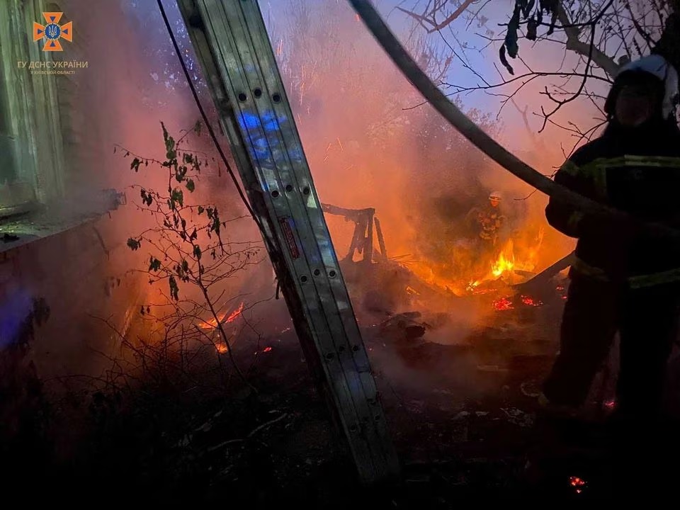 Petugas pemadam kebakaran bekerja di lokasi bangunan pribadi yang rusak selama serangan udara besar-besaran Rusia, di tengah serangan Rusia di Ukraina, di wilayah Kyiv, Ukraina 29 Mei 2023. Foto: Layanan pers Layanan Darurat Negara Ukraina di wilayah Kyiv/Reuters.