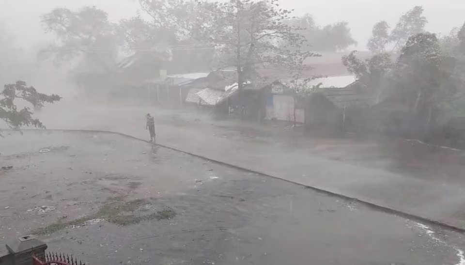 Seorang pria berdiri di tengah angin kencang dan hujan deras di kamp ThekayPyin Rohingya, saat Topan Mocha mendekat, di Sittwe, Rakhine, Myanmar, 14 Mei 2023 dalam tangkapan layar yang diambil dari video selebaran. Foto: Reuters/HO.