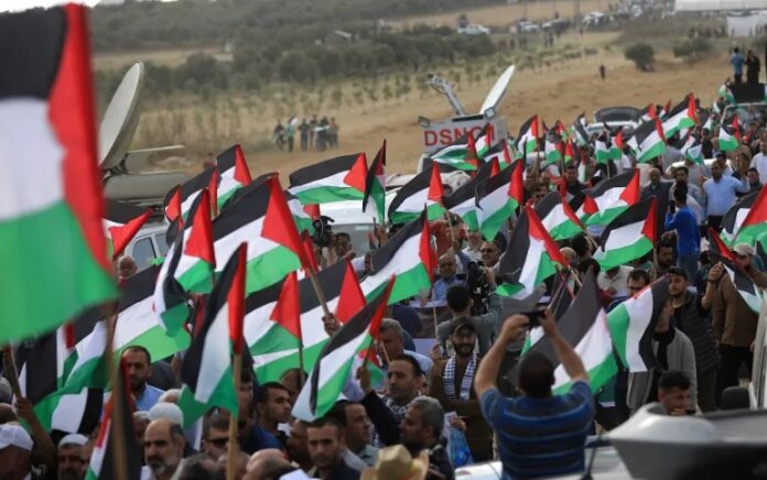 Warga Palestina di Gaza bergabung dalam pawai di dekat perbatasan timur, memprotes pawai bendera pemukim di Yerusalem pada Kamis, 18 Mei 2023. Foto: Abdelhakim Abu Riash, Al Jazeera.