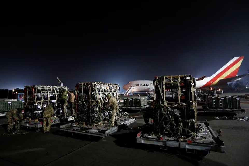 Anggota layanan Ukraina membongkar rudal anti-tank Javelin, dikirim dengan pesawat sebagai bagian dari paket dukungan militer AS untuk Ukraina, di Bandara Internasional Boryspil di luar Kyiv, Ukraina 10 Februari 2022. Foto: Reuters/Valentyn Ogirenko.