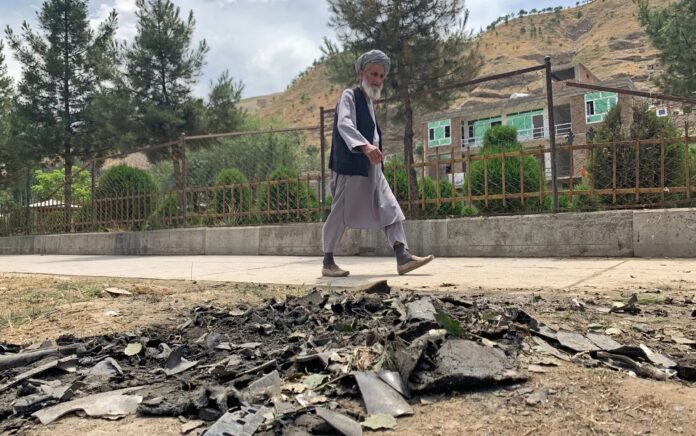 Seorang pria berjalan melewati lokasi serangan bunuh diri di sepanjang pinggir jalan di distrik Faizabad di provinsi Badakhshan pada 6 Juni 2023. Foto: Omer Abrar/AFP via Getty Images.