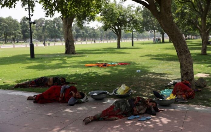 Buruh wanita beristirahat di bawah pohon pada hari musim panas di dekat Gerbang India, di New Delhi, India 15 Mei 2023. Foto: Reuters/Anushree Fadnavis/File Foto.