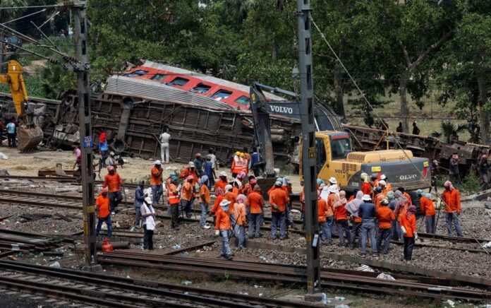 Alat berat memindahkan gerbong yang rusak dari rel kereta api di lokasi tabrakan kereta api setelah kecelakaan di distrik Balasore di negara bagian timur Odisha, India, 4 Juni 2023. Foto: Reuters/Adnan Abidi.