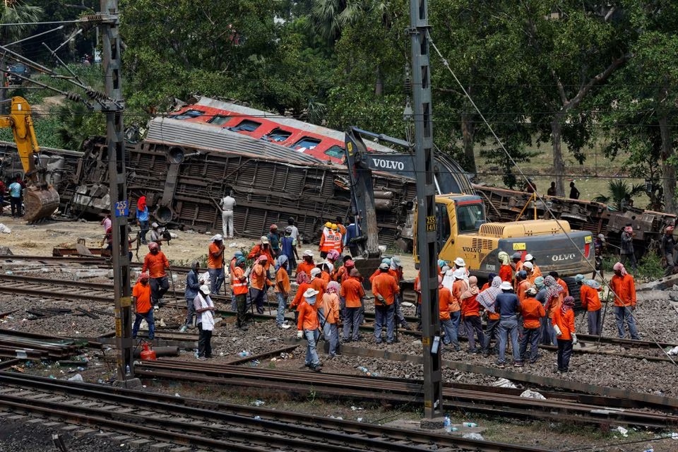 Alat berat memindahkan gerbong yang rusak dari rel kereta api di lokasi tabrakan kereta api setelah kecelakaan di distrik Balasore di negara bagian timur Odisha, India, 4 Juni 2023. Foto: Reuters/Adnan Abidi.