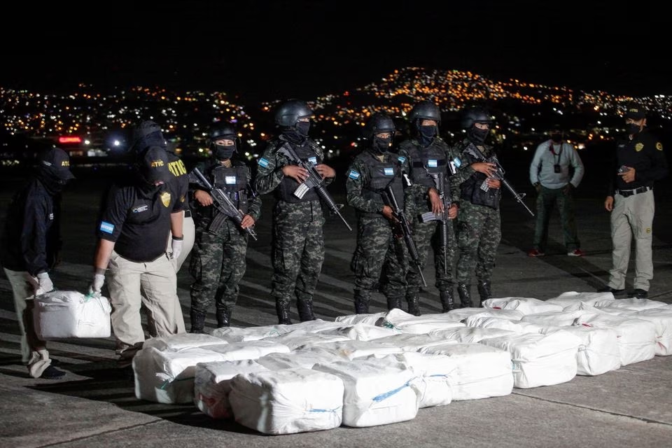 Petugas Badan Teknis Investigasi Kriminal Honduras membawa paket berisi kokain yang disita selama operasi polisi, dalam presentasi ke media, di Tegucigalpa, Honduras, 11 Desember 2022. Foto: Reuters/Fredy Rodriguez.