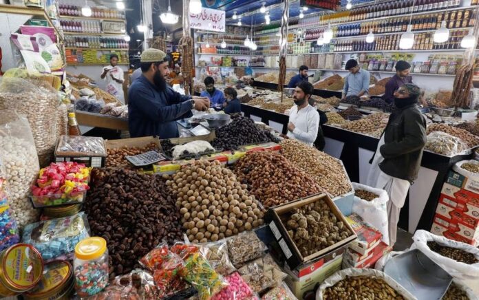 Orang-orang membeli buah-buahan kering di sebuah pasar di Karachi, Pakistan, 1 Februari 2023. Foto: Reuters/Akhtar Soomro.