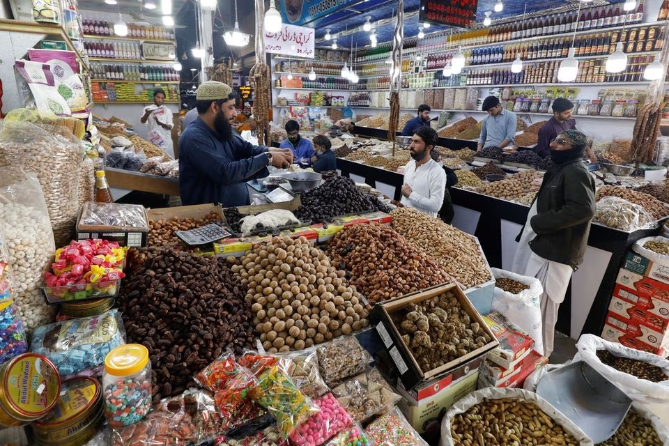 Orang-orang membeli buah-buahan kering di sebuah pasar di Karachi, Pakistan, 1 Februari 2023. Foto: Reuters/Akhtar Soomro.