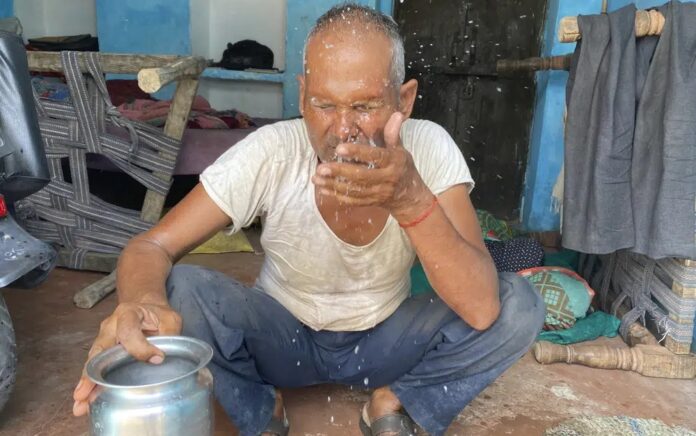 Seorang pria lanjut usia memercikkan air ke wajahnya untuk menyejukkan diri di sore musim panas yang terik di Lalitpur, negara bagian Uttar Pradesh, India, Sabtu, 17 Juni 2023. Foto: AP/Rajesh Kumar Singh.