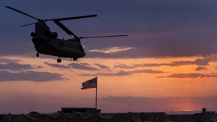 Helikopter CH-47 Chinook Angkatan Darat A.S. lepas landas saat matahari terbenam saat mengangkut pasukan Amerika keluar dari pos tempur terpencil yang dikenal sebagai RLZ. Foto: John Moore/Getty Images.