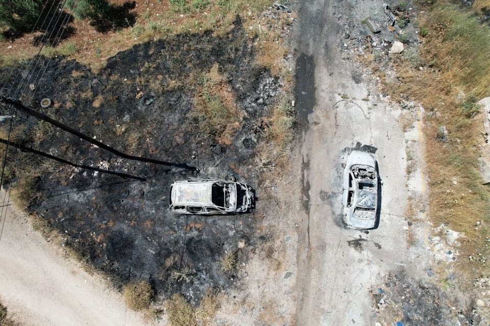 Pemandangan udara menunjukkan kendaraan yang terbakar setelah serangan pemukim Israel di dekat Ramallah di Tepi Barat yang diduduki Israel, 21 Juni 2023. Foto: Reuters/Ammar Awad.