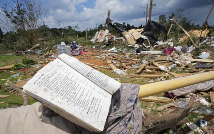 Sebuah buku doa terletak di penghalang parkir di antara puing-puing dari tornado Minggu malam yang melanda Louin, Miss., Senin, 19 Juni 2023. Foto: AP/Rogelio V. Solis.