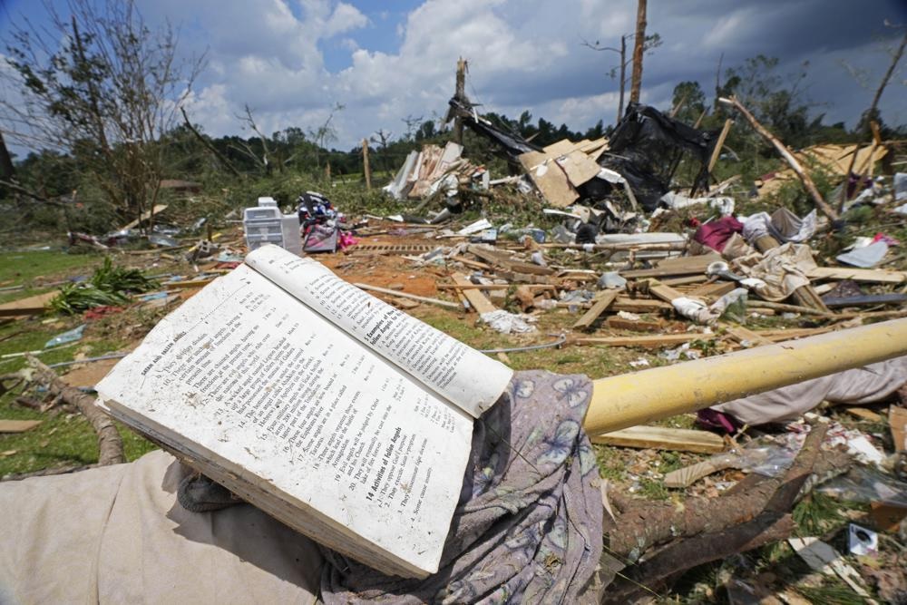 Sebuah buku doa terletak di penghalang parkir di antara puing-puing dari tornado Minggu malam yang melanda Louin, Miss., Senin, 19 Juni 2023. Foto: AP/Rogelio V. Solis.