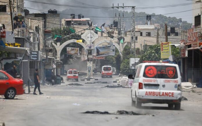 Asap mengepul saat ambulans melaju selama operasi militer Israel di Jenin, di Tepi Barat yang diduduki Israel 3 Juli 2023. Foto: Reuters/Raneen Sawafta.