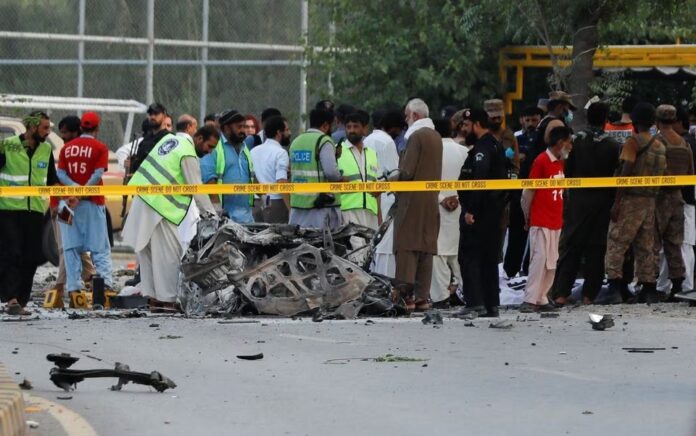 Tentara, polisi, dan petugas penyelamat berkumpul di lokasi serangan bunuh diri di dekat kendaraan pasukan paramiliter di Peshawar, Pakistan 18 Juli 2023. Foto: Reuters/Fayaz Aziz.