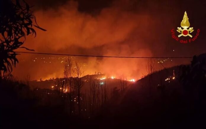 Api dan asap mengepul saat kebakaran hutan terjadi di dekat desa Sisilia Curcuraci dekat Messina, Italia, 25 Juli 2023. Foto: Vigili del Fuoco/Reuters.