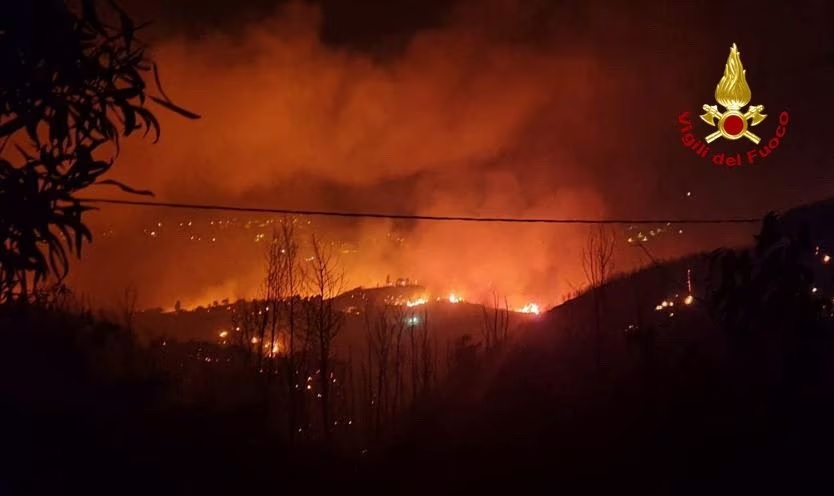 Api dan asap mengepul saat kebakaran hutan terjadi di dekat desa Sisilia Curcuraci dekat Messina, Italia, 25 Juli 2023. Foto: Vigili del Fuoco/Reuters.