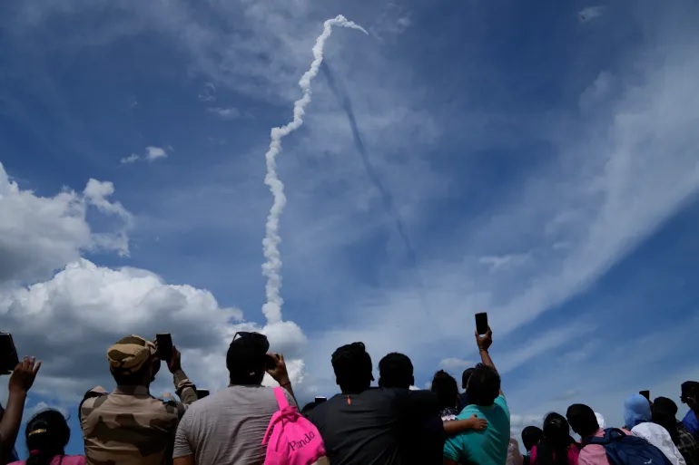Orang-orang menyaksikan peluncuran Chandrayaan-3 di Sriharikota, India, Jumat, 14 Juli 2023. Foto: Aijaz Rahi/AP.