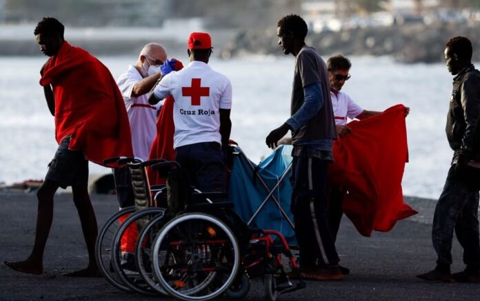 Migran berjalan menuju tenda Palang Merah setelah turun dari kapal penjaga pantai Spanyol di pelabuhan Arguineguin, pulau Gran Canaria, Spanyol, 10 Juli 2023. Foto: Reuters/Borja Suarez.