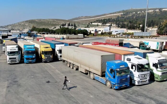 Truk yang membawa bantuan dari Program Pangan Dunia PBB (WFP), menyusul gempa mematikan, diparkir di persimpangan Bab al-Hawa, Suriah 20 Februari 2023. Foto: Reuters/Mahmoud Hassano/File Foto.