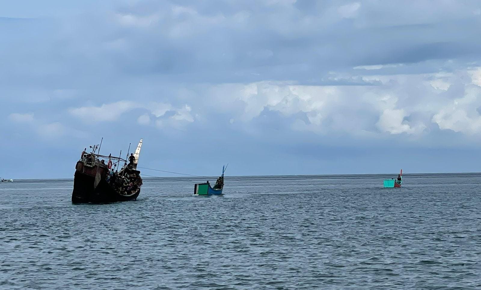 Dua boat kecil milik warga menarik perahu etnis Rohingya ke laut saat ingin mendarat di tepi pantai Gampong Pulo Pineung Meunasah Dua, Kecamatan Jangka, Kabupaten Bireuen, Provinsi Aceh, Kamis (16/11) dini hari sekira pukul 04.30 WIB.
