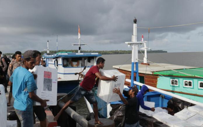 Petugas memindahkan logistik Pemilihan Umum (Pemilu) Tahun 2024 ke kapal di Distrik Agats yang akan didistribusikan ke distrik terluar, Sabtu (10/2/2024). (Foto: Antara)