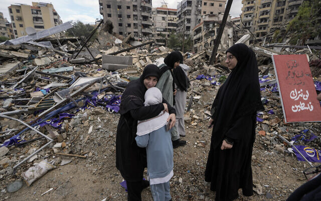 Seorang wanita memeluk putrinya yang menangis saat warga yang mengungsi kembali ke Dahiyeh, di Beirut, Lebanon, menyusul gencatan senjata antara Israel dan Hizbullah, Rabu, 27 November 2024. (Foto AP/Bilal Hussein)